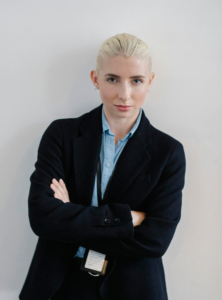 Professional businesswoman standing confidently with arms crossed in an office setting.